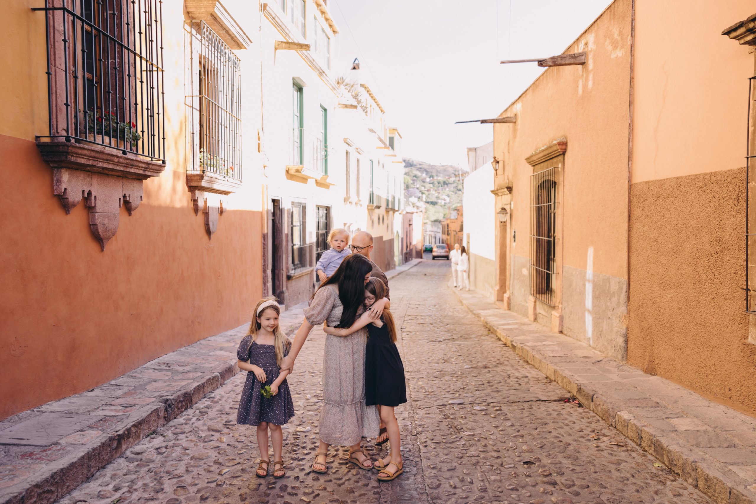 family hugging and walking in the streets of san miguel del allende
